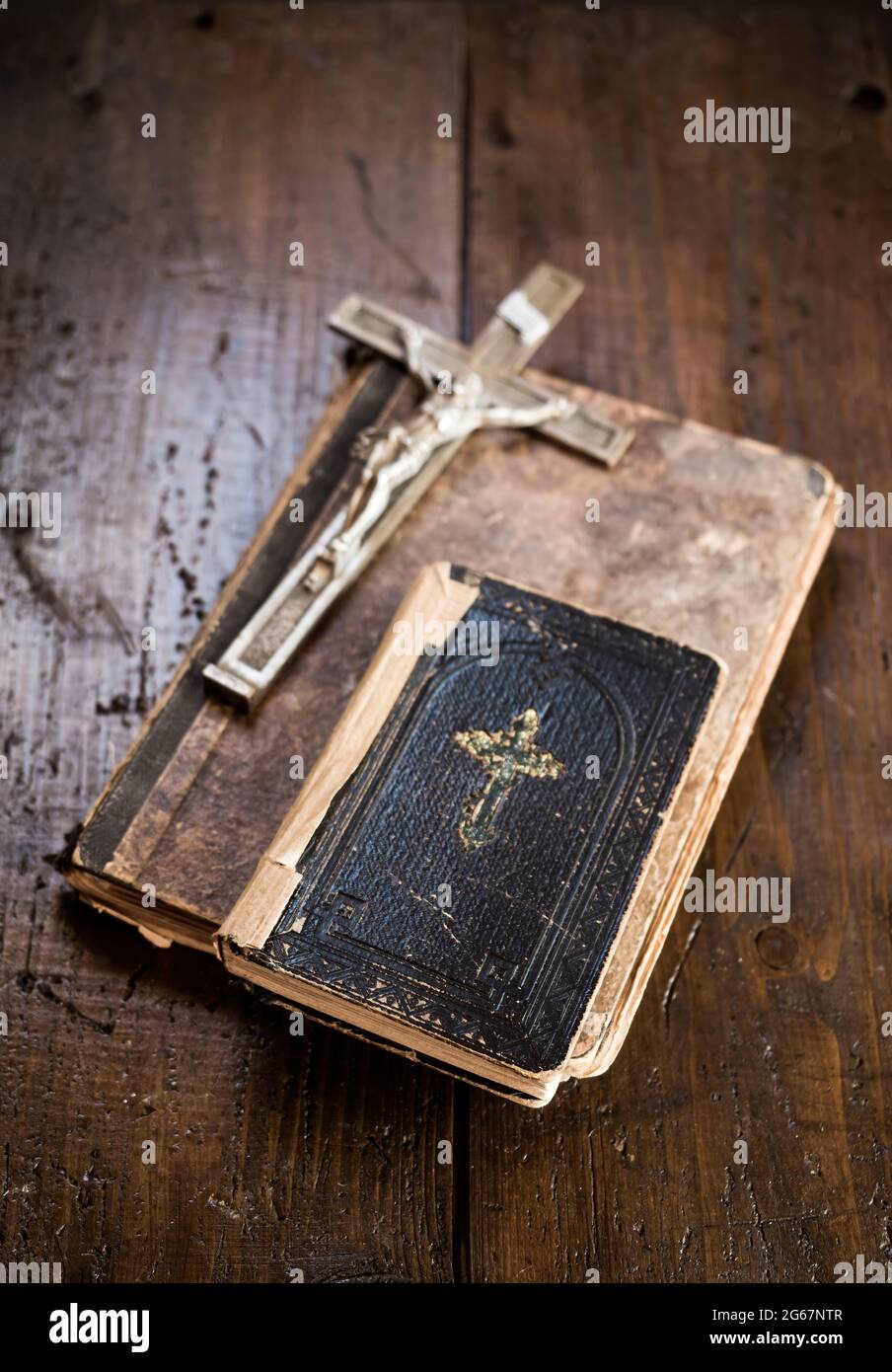 Crocifisso e Sacra Bibbia che si stendono su un vecchio libro su una tavola rustica di legno. Cristianesimo, religione, simbolo religioso. Preghiera. Foto Stock