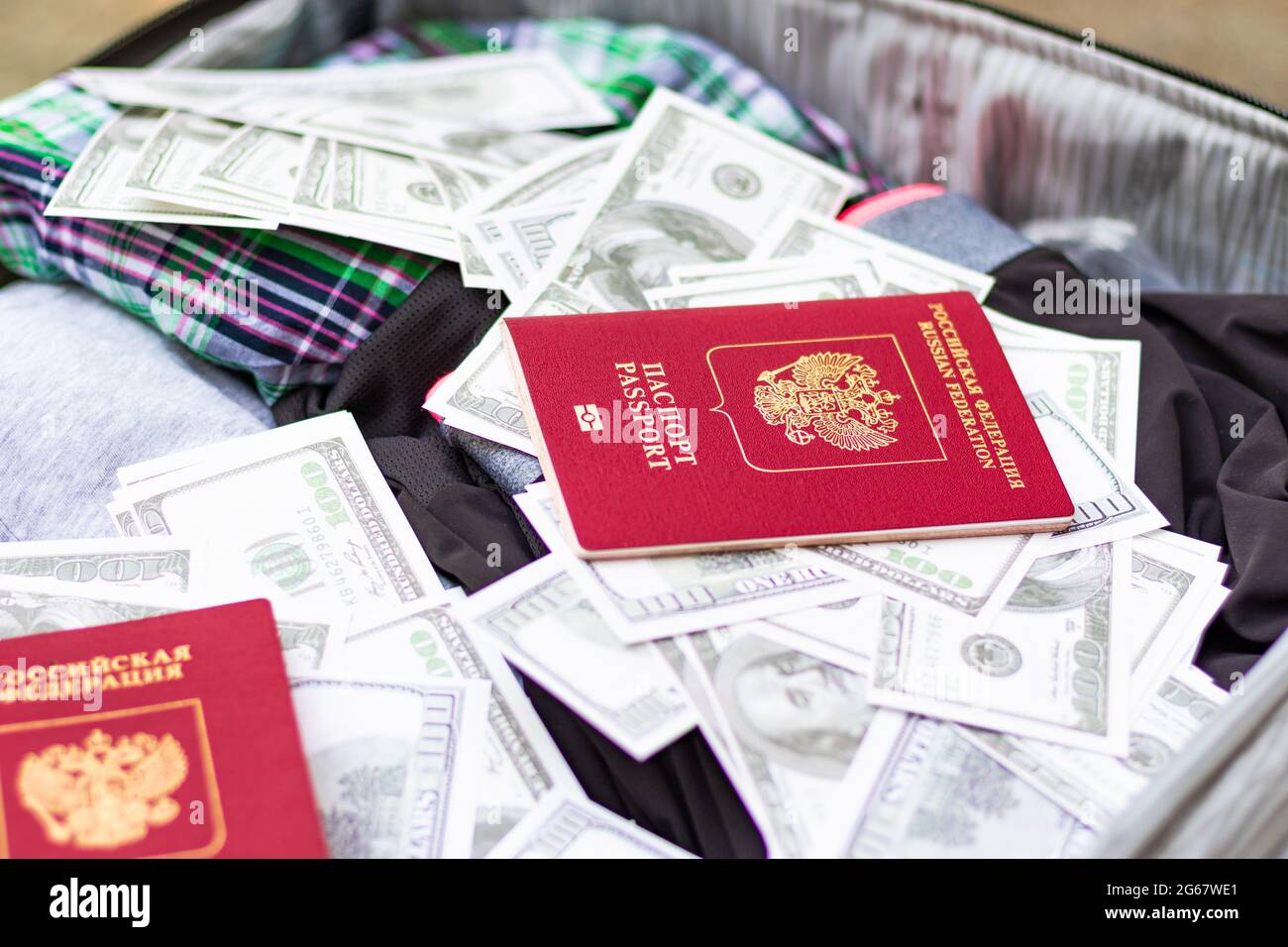 Due passaporti e un sacco di soldi in una valigia di viaggio con le cose in una giornata estiva soleggiato. Messa a fuoco selettiva Foto Stock