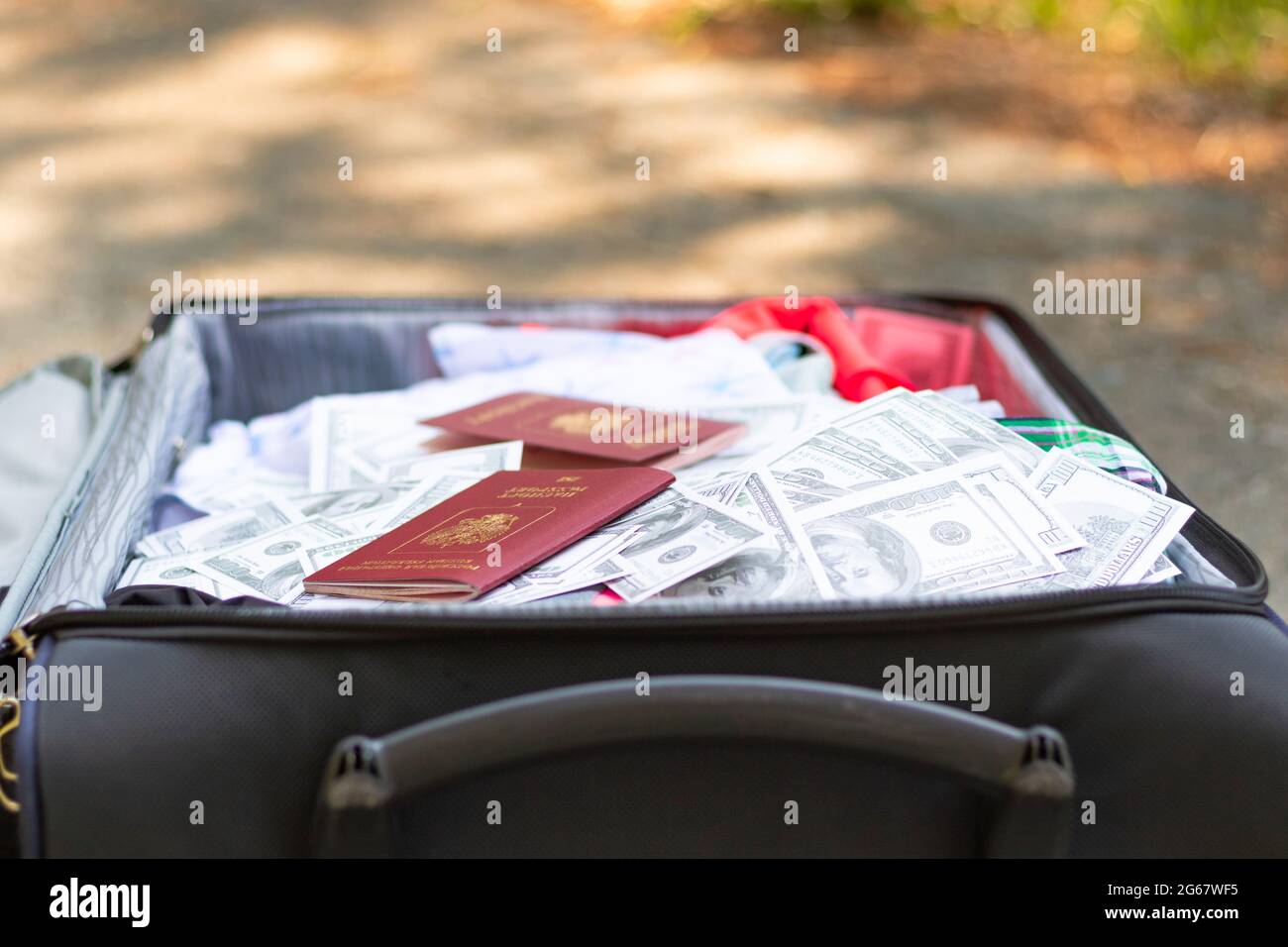Due passaporti e un sacco di soldi in una valigia di viaggio con le cose in una giornata estiva soleggiato. Messa a fuoco selettiva Foto Stock