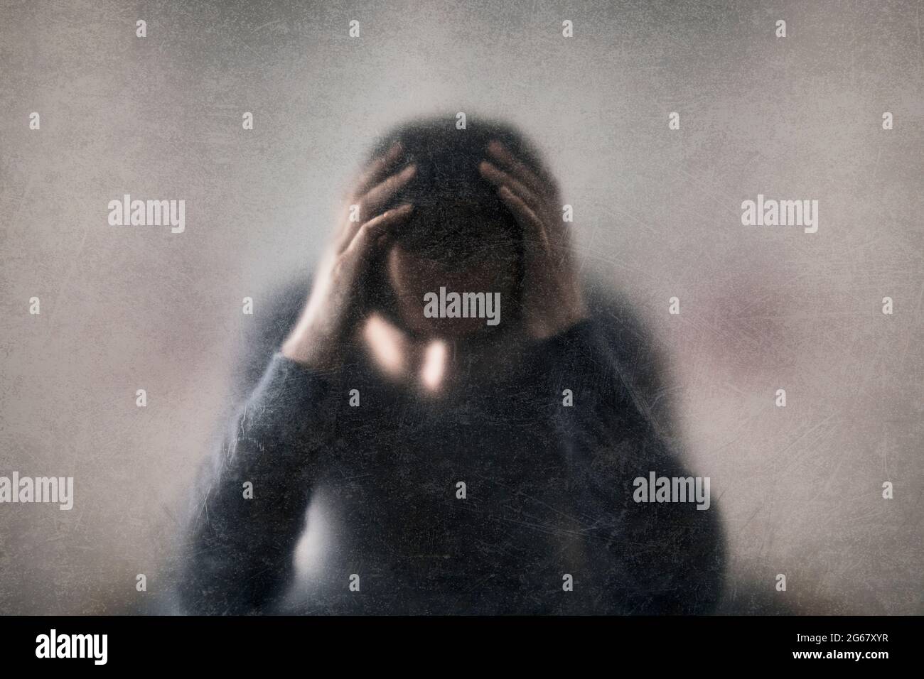 La depressione. Rotture di uomo dietro un polveroso vetro graffiato. Foto Stock