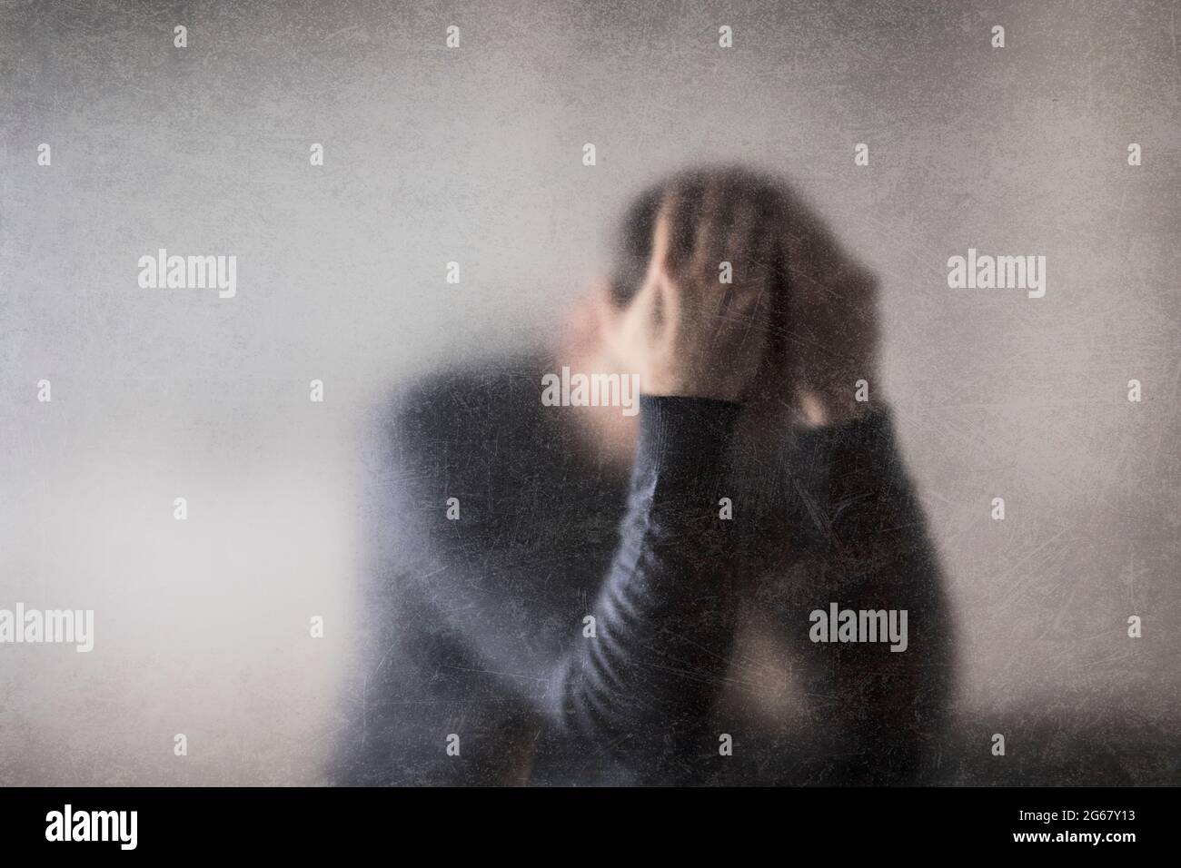 La depressione. Rotture di uomo dietro un polveroso vetro graffiato. Foto Stock