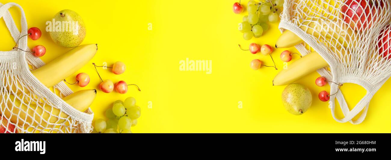 Frutta matura in un sacchetto di maglia su sfondo giallo. Borsa a filo di cotone ecologica per lo shopping. Alimenti vegetariani dietetici organici. Formato banner. Foto Stock