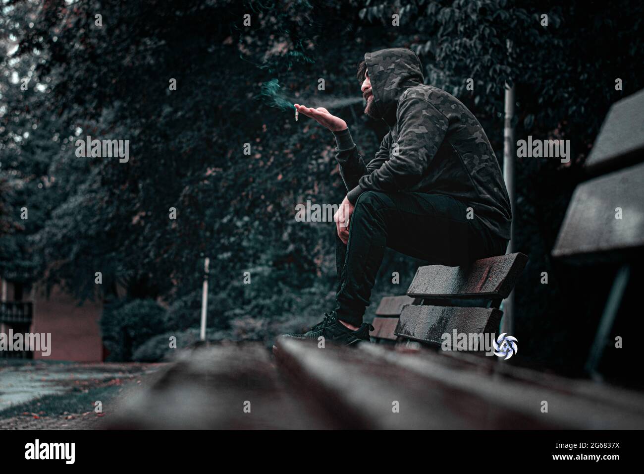 Uomo che fuma seduto sul divano nel giardino Lazy uomo che passa la giornata a fumare sigarette Foto Stock Uomo che fuma seduto sul divano nel giardino Lazy uomo che passa la giornata a fumare sigarette Foto Stock