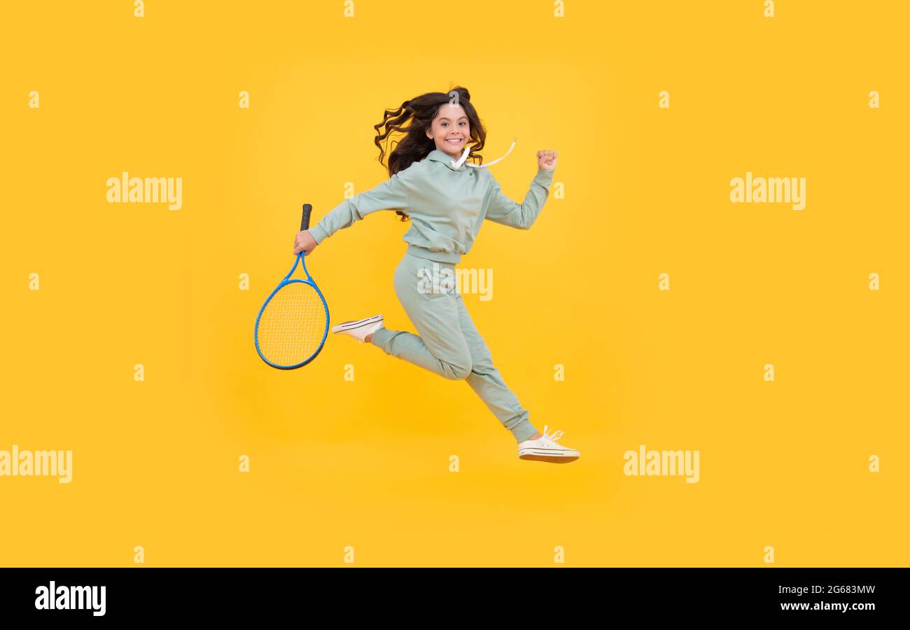 felice salto energico bambino con squash racket correre al successo, successo sportivo. Foto Stock