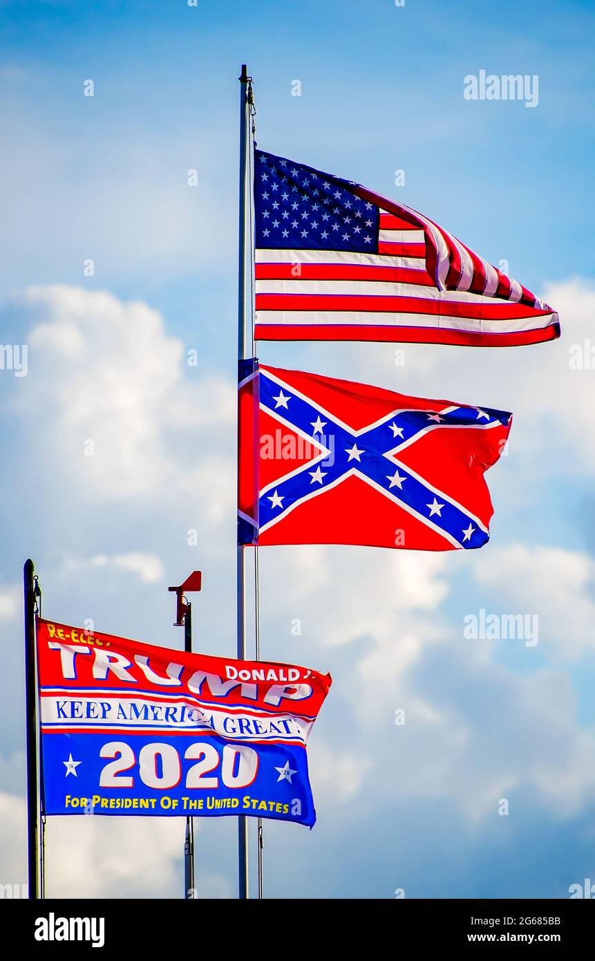 Una bandiera Trump 2020 vola accanto a una bandiera americana e a una bandiera confederata in un molo di Coden Beach, 1 luglio 2021, a Coden, Alabama. Foto Stock