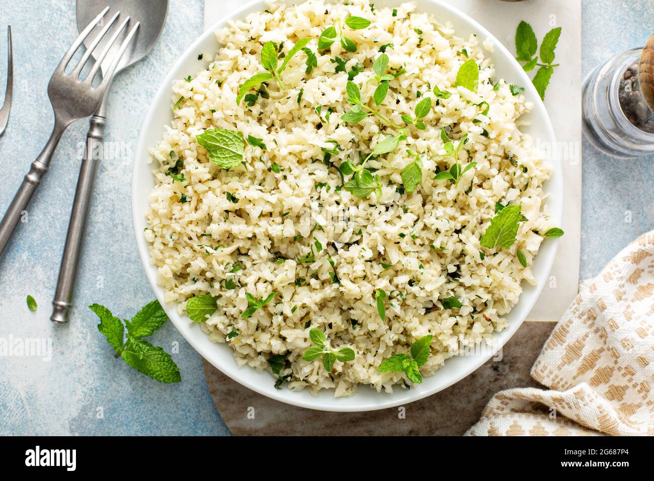 Riso al cavolfiore con erbe e succo di limone in una ciotola bianca Foto Stock