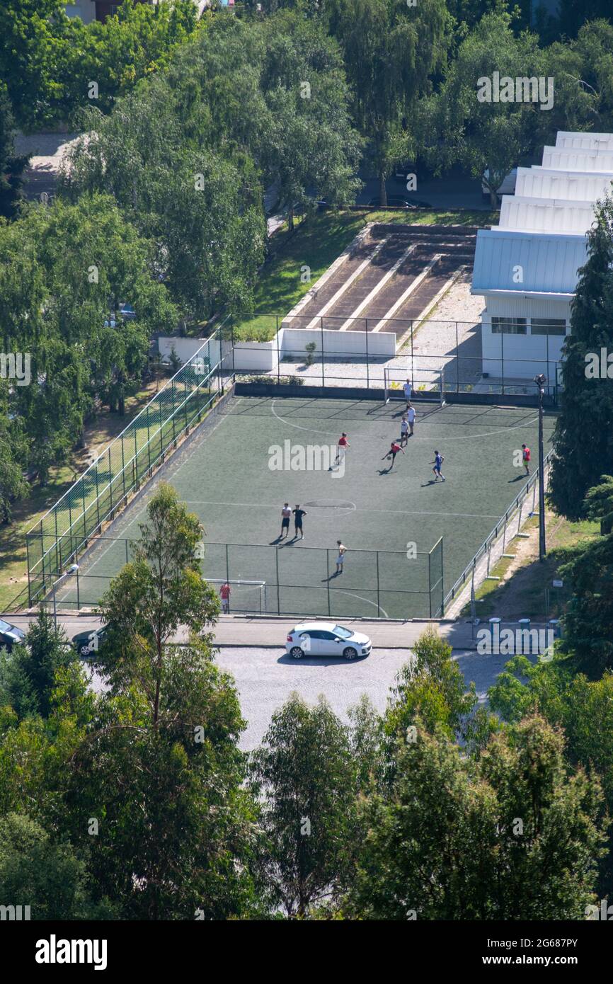 Bambini o adolescenti che giocano a calcio nei campi di calcio della città Foto Stock