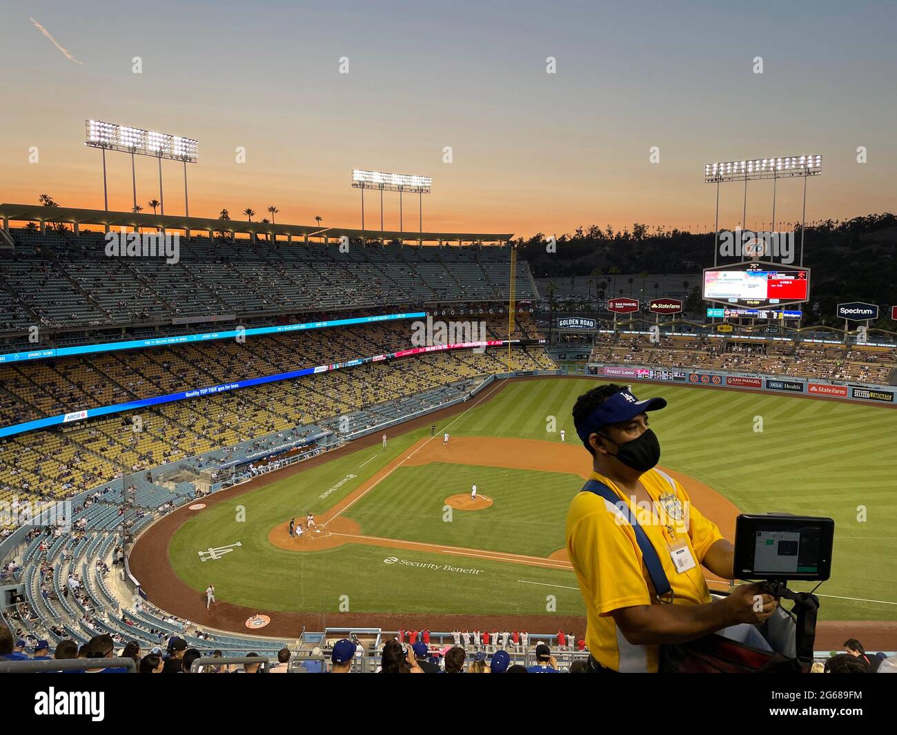 Fornitore che prende il pagamento con un piccolo dispositivo elettronico durante la partita di baseball notturna al Dodger Stadium di Los Angeles, California Foto Stock