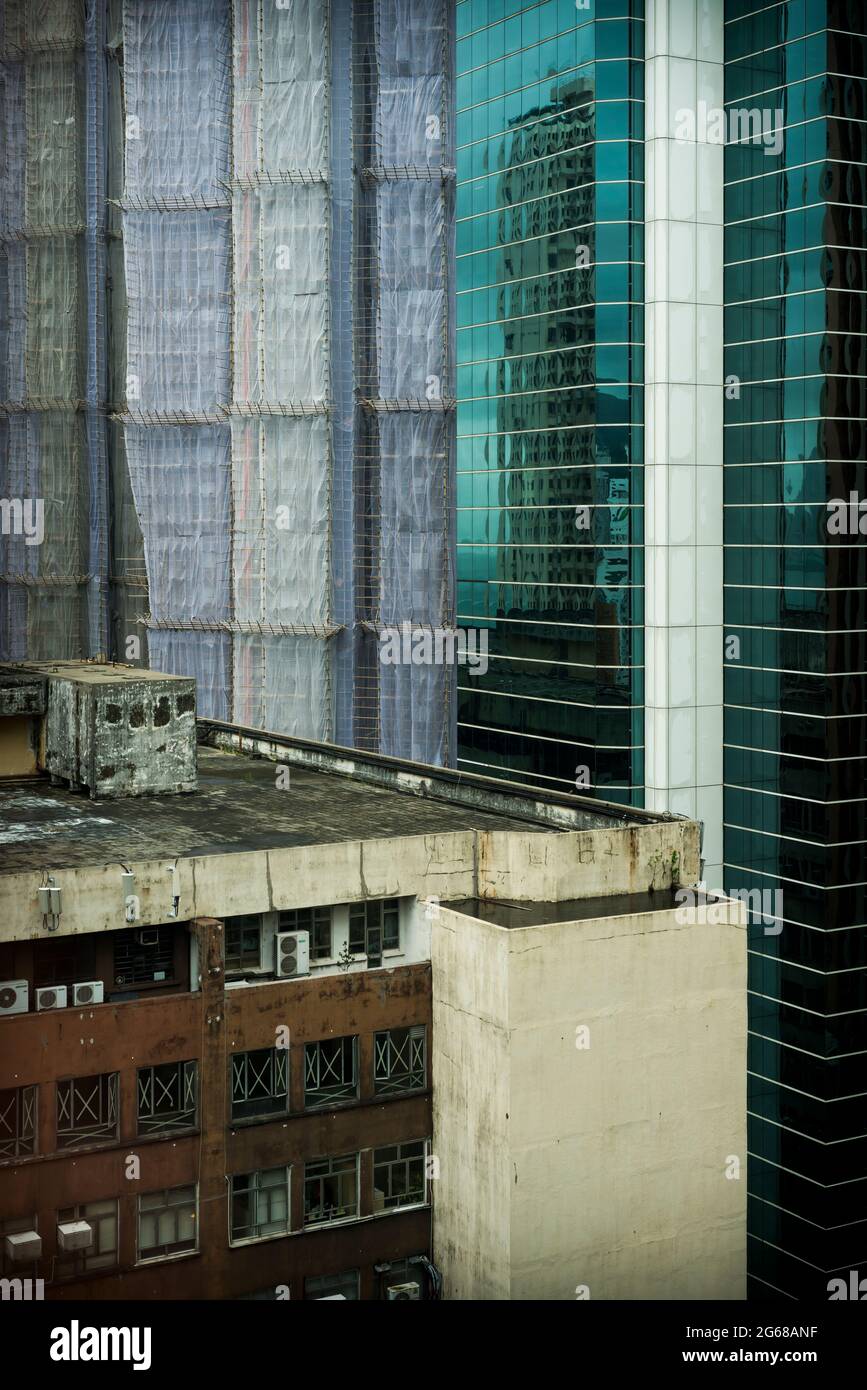 Vecchio e nuovo: La cima di un vecchio edificio e un'alta torre commerciale, con un altro in costruzione, Causeway Bay, Hong Kong Island Foto Stock