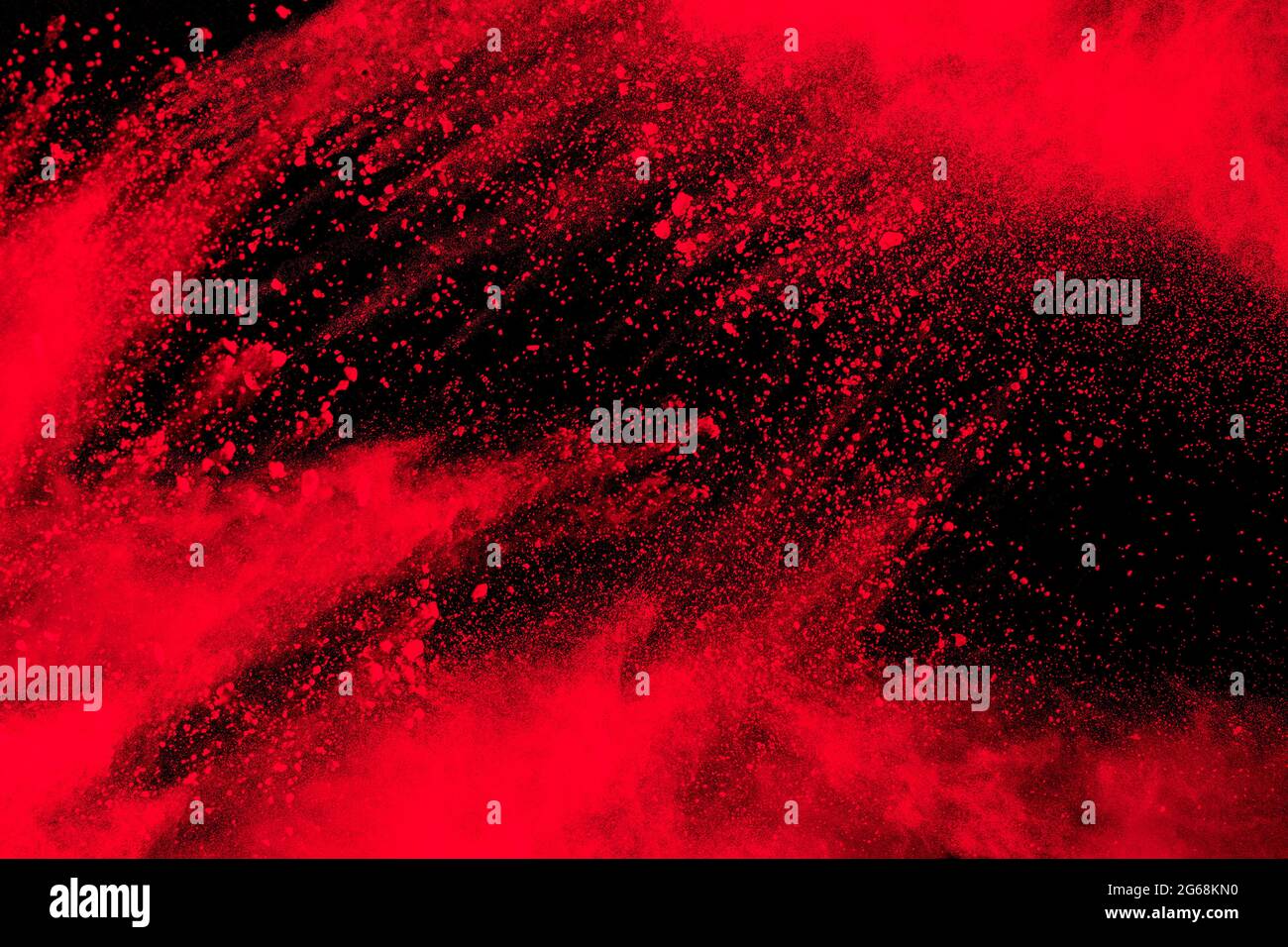 Esplosione di particelle rosse su sfondo nero.Freeze movimento di spruzzi di polvere rossa. Foto Stock