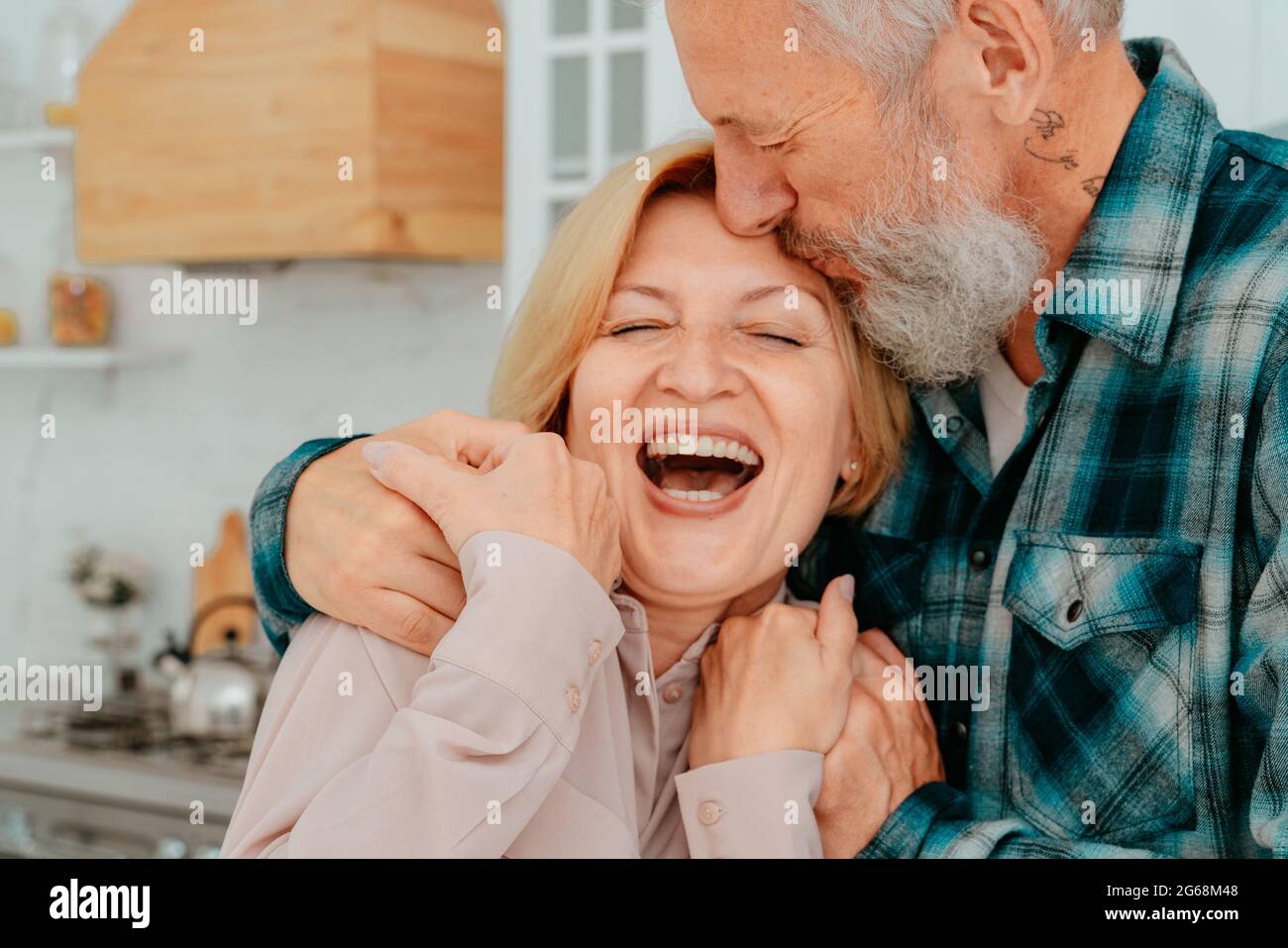 Marito e moglie in pensione si abbracciano a casa Foto Stock