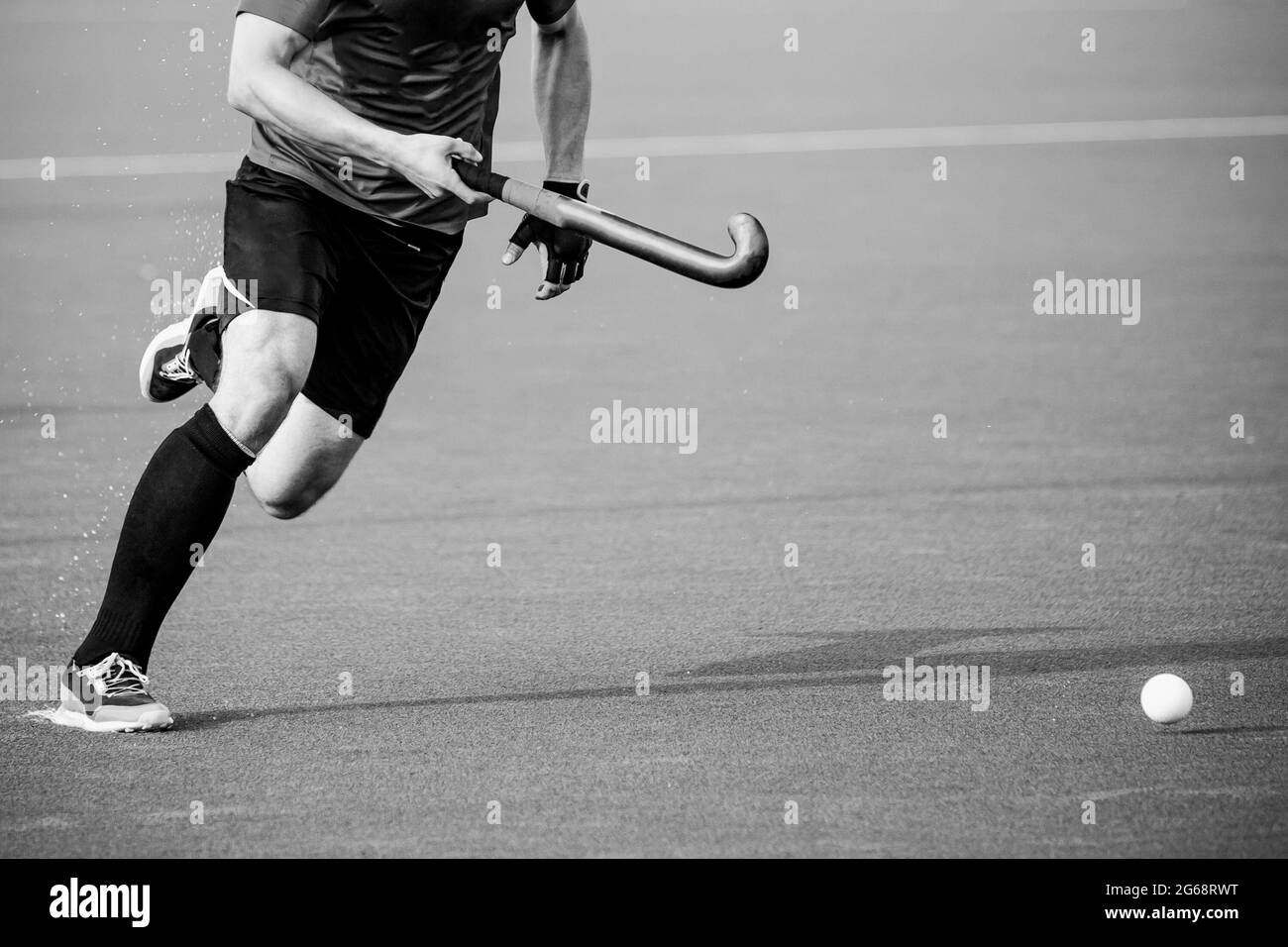 Giocatore di hockey su campo su campo di gioco erba artificiale. Foto Stock