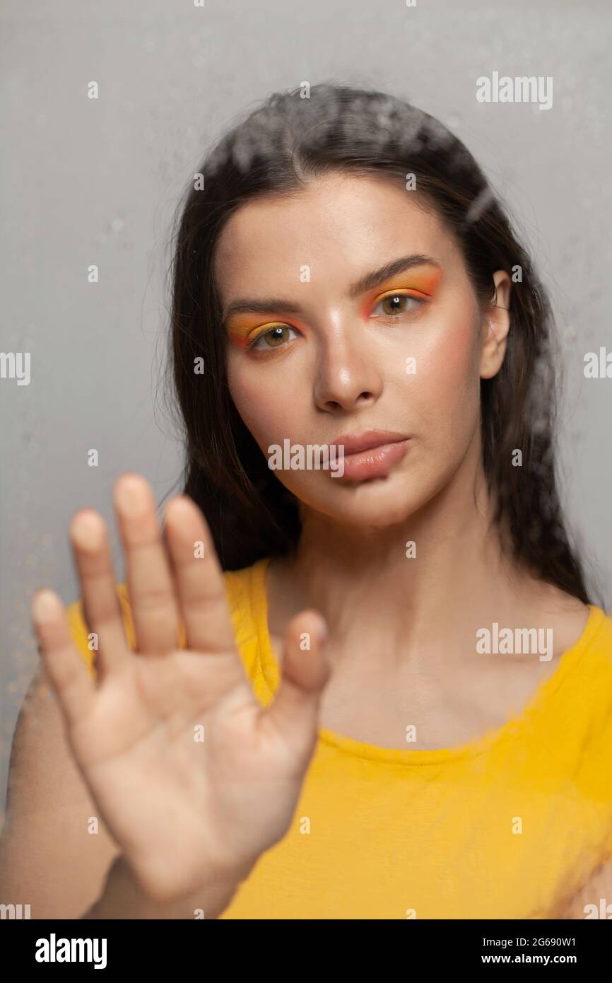 Concetto di solitudine, tristezza e disturbo mentale. Donna dietro un bicchiere bagnato Foto Stock