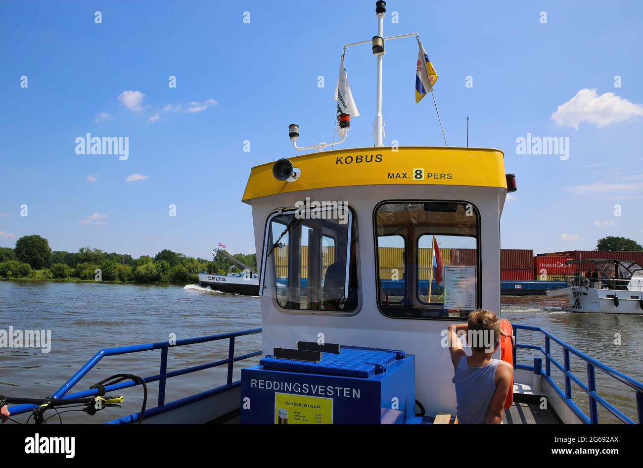 Blitterswijck, Paesi Bassi - 1 luglio. 2021: Vista sulla cabina del conducente di traghetto per piccoli passeggeri e biciclette (voet- en fietsveer) sul fiume maas, container sh Foto Stock