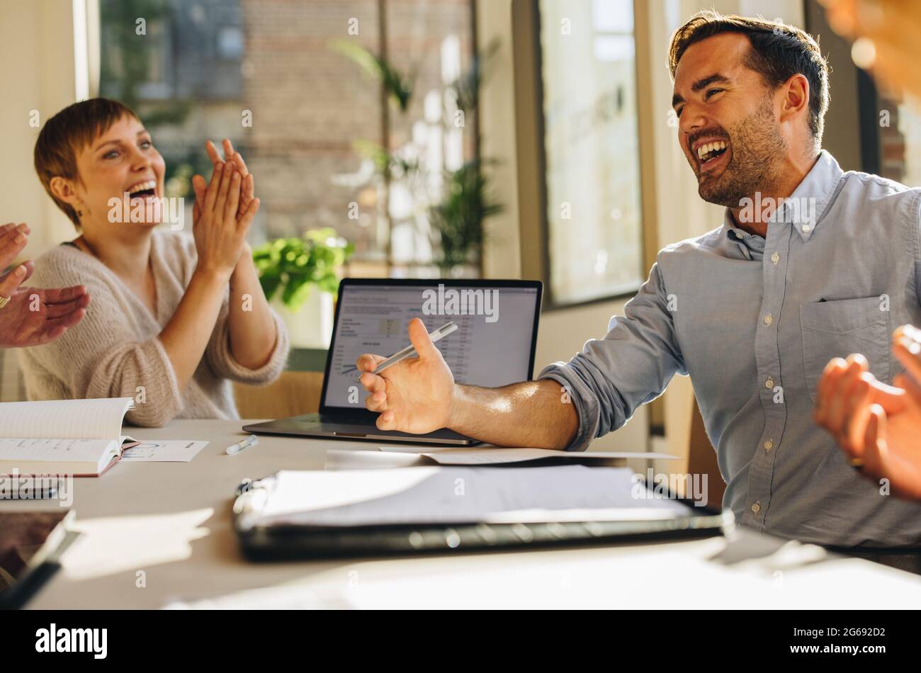 Uomo che spiega idee creative ai colleghi. Riunione dei colleghi in una sala riunioni e discussione sull'imprenditorialità delle startup. Foto Stock