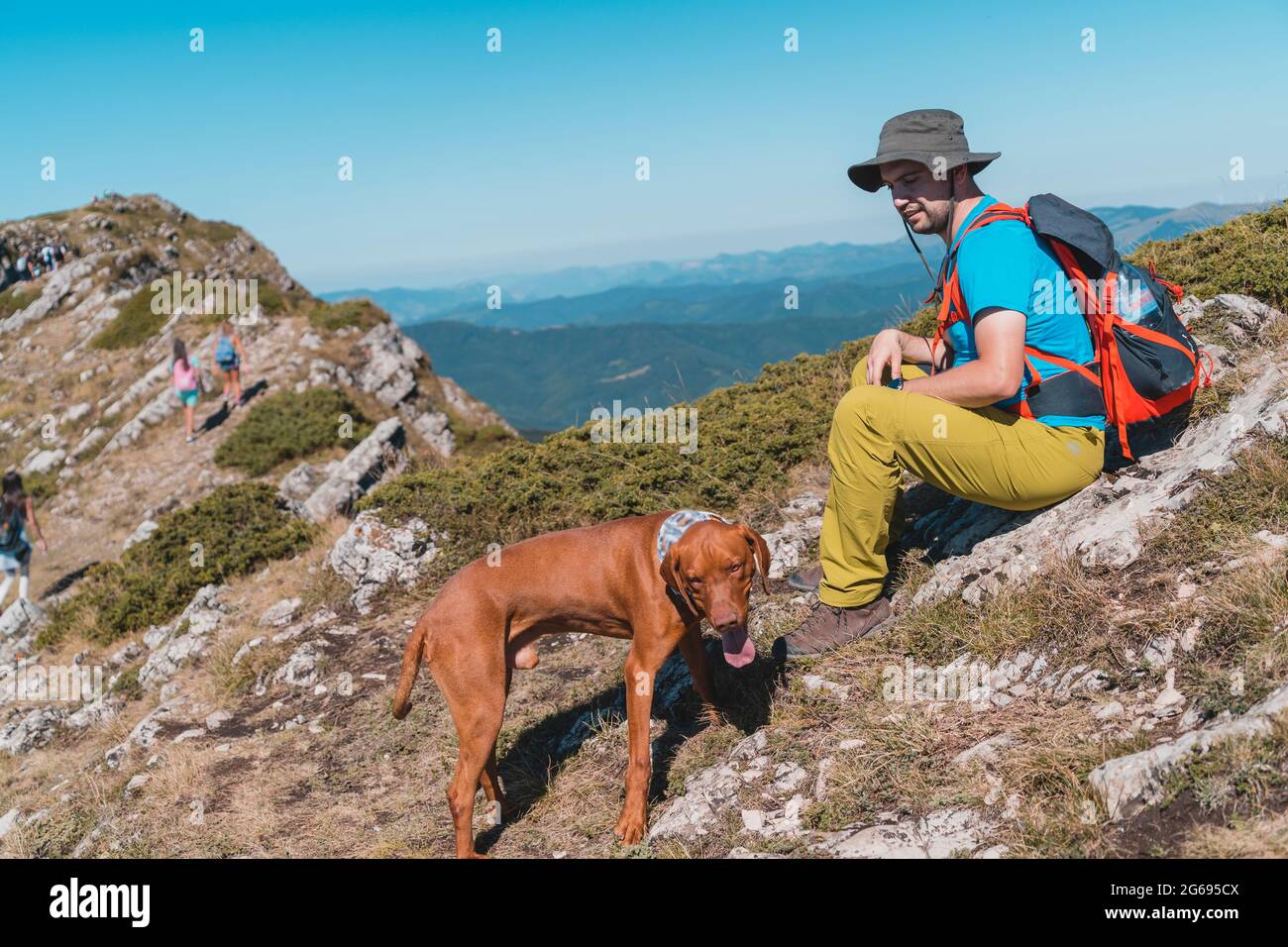 Giovane uomo che camminava in montagna con il suo cane Foto Stock