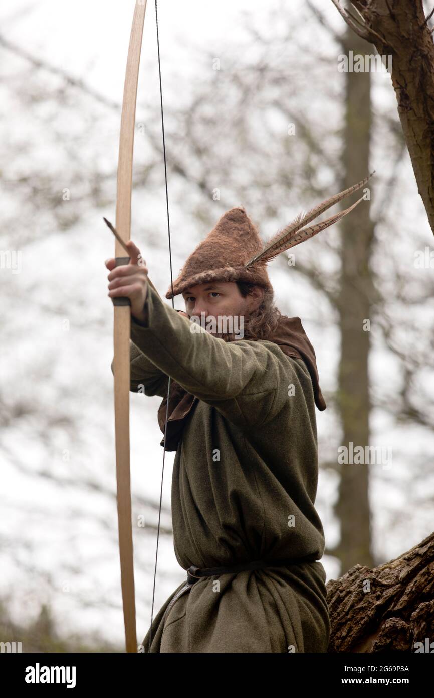 Interpretazione del leggendario fuorilegge inglese Robin Hood nella foresta di Sherwood con il suo longbow Foto Stock