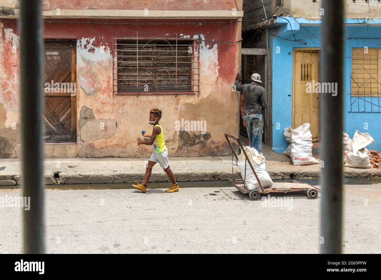Un bambino cubano con una palla cammina in un cantiere privato in una casa a Santiago de Cuba, Cuba Foto Stock