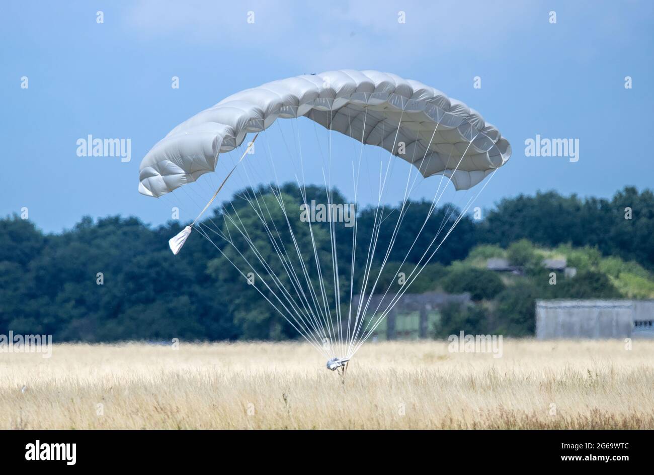 Trollenhagen, Germania. 04 luglio 2021. I paracadutisti del comando delle forze speciali della Bundeswehr atterrano in un campo aereo durante uno scenario di esercizio. Circa 400 soldati del comando delle forze speciali vogliono addestrare il rilascio degli ostaggi durante l'esercizio 'Black Star 2021' vicino a Neubrandenburg. L'esercizio si concentra sull'interazione dell'elicottero multifunzione NH90, dell'aereo A400 M, dei paracadutisti, dei medici e delle unità di ricognizione. Credit: Jens Büttner/dpa-Zentralbild/dpa/Alamy Live News Foto Stock