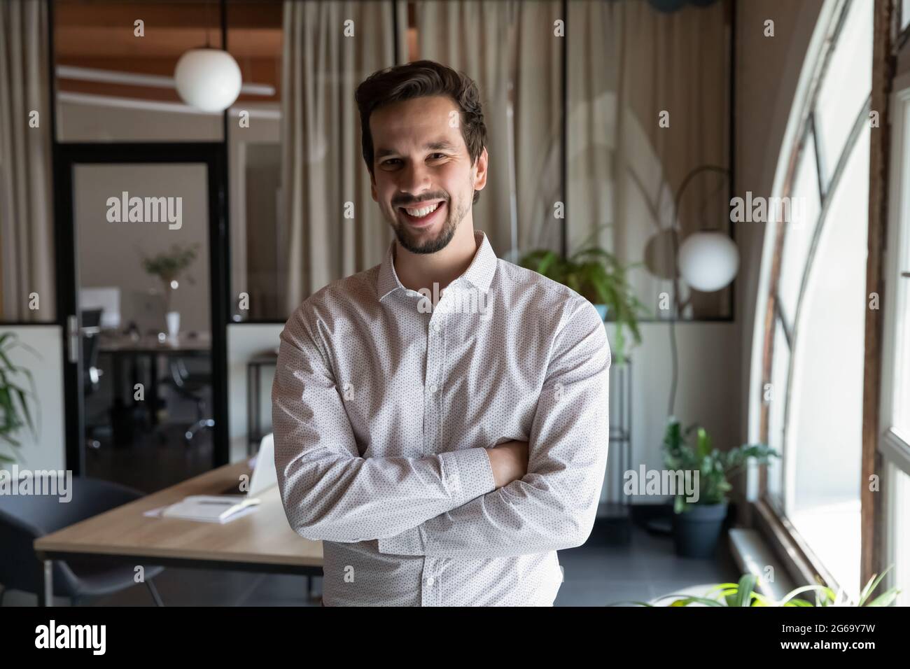 Ritratto di un uomo d'affari sorridente con le braccia incrociate Foto Stock