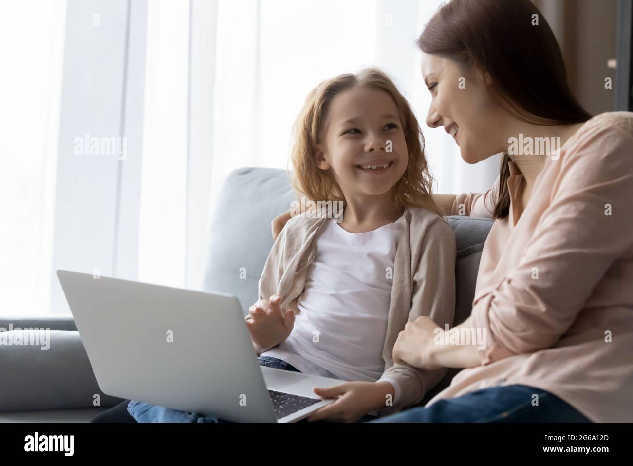 Giovane nanny e ragazza presea guardano il canale di formazione sul laptop Foto Stock