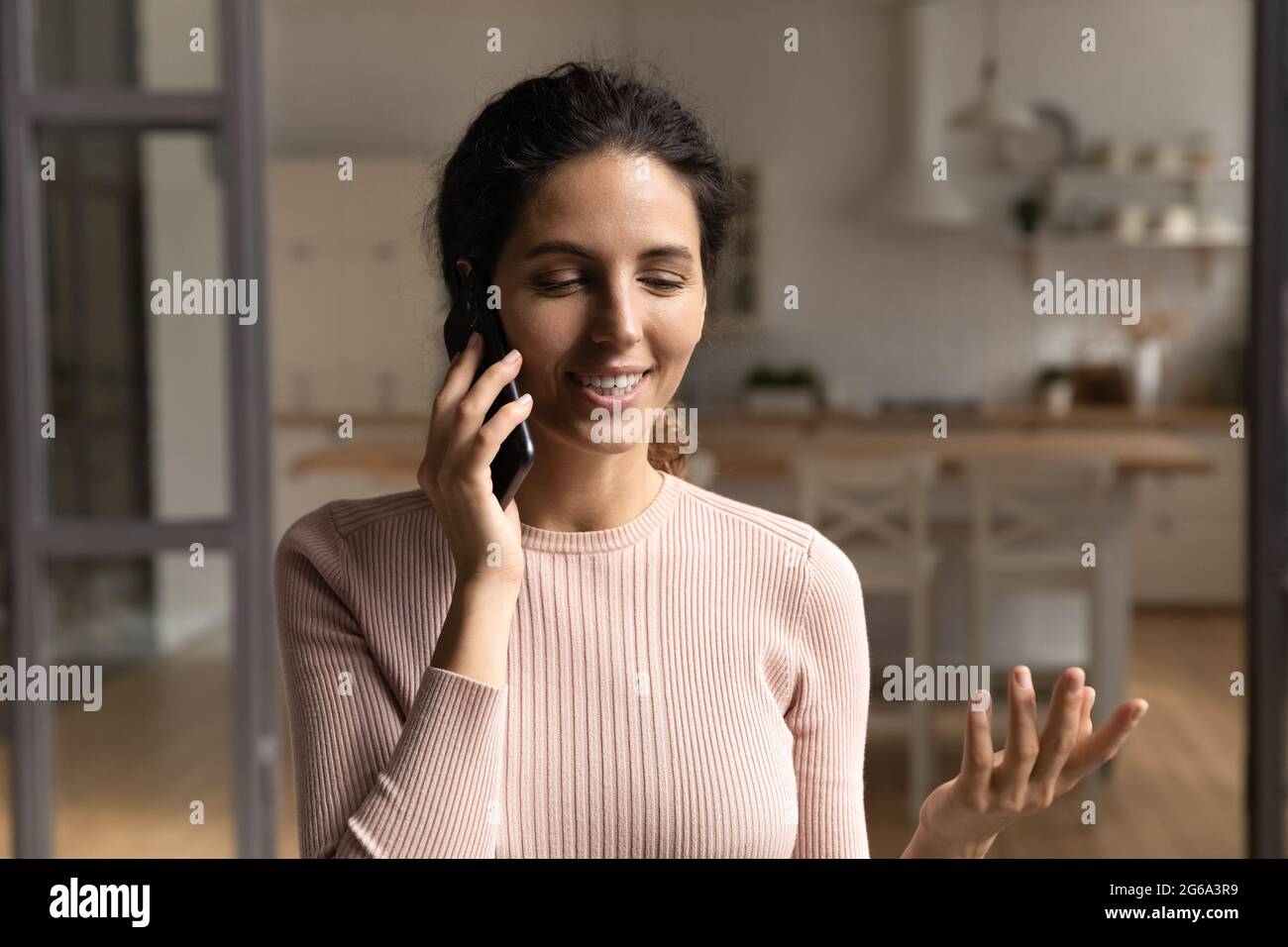 Felice bella giovane donna che tiene la conversazione del cellulare. Foto Stock