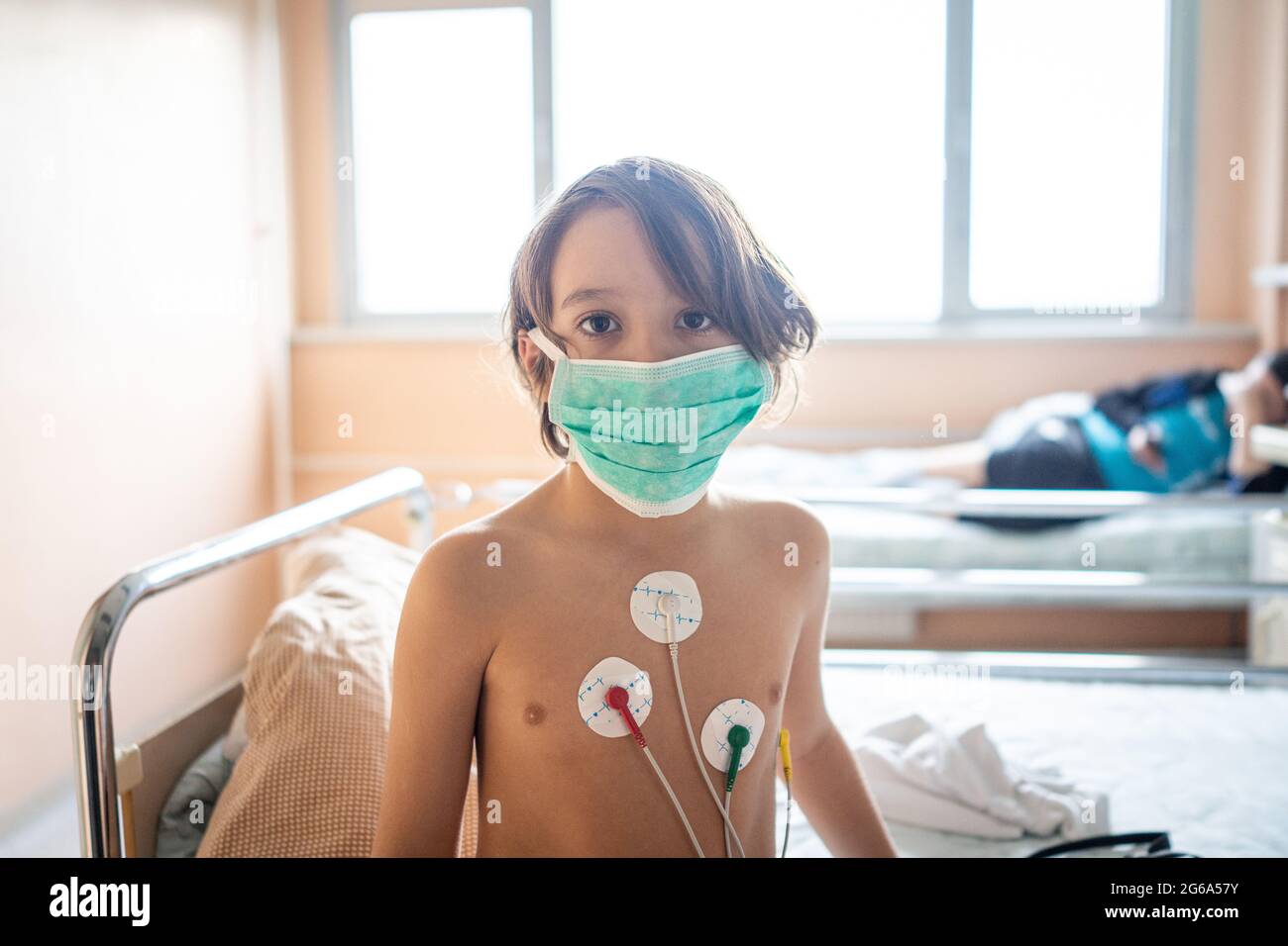 Piccolo ragazzo carino in ospedale a letto al coperto Foto Stock