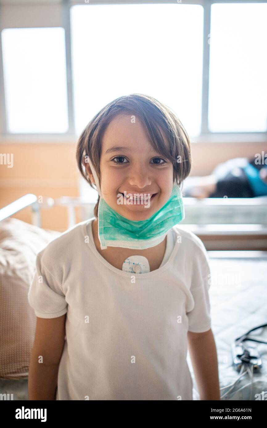 Piccolo ragazzo carino in ospedale a letto al coperto Foto Stock