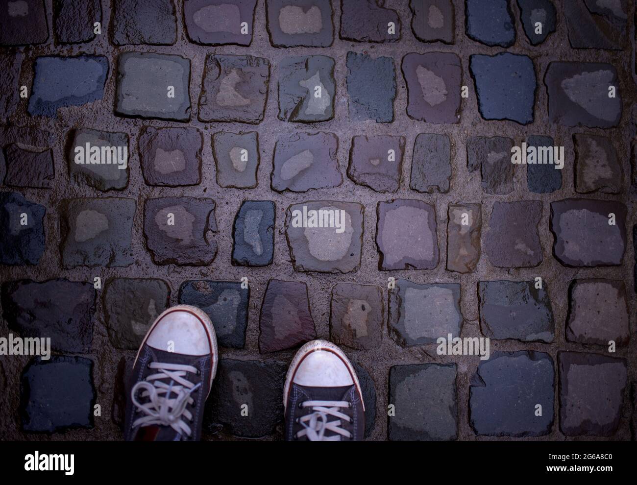 scarpe sullo sfondo di una vecchia pietra da pavimentazione bagnata dopo la pioggia Foto Stock