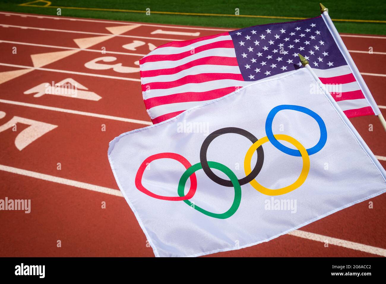 MIAMI, Stati Uniti d'America - agosto, 2019: Un Olympic e bandiera americana al flutter insieme al di sopra di un rosso pista atletica. Foto Stock