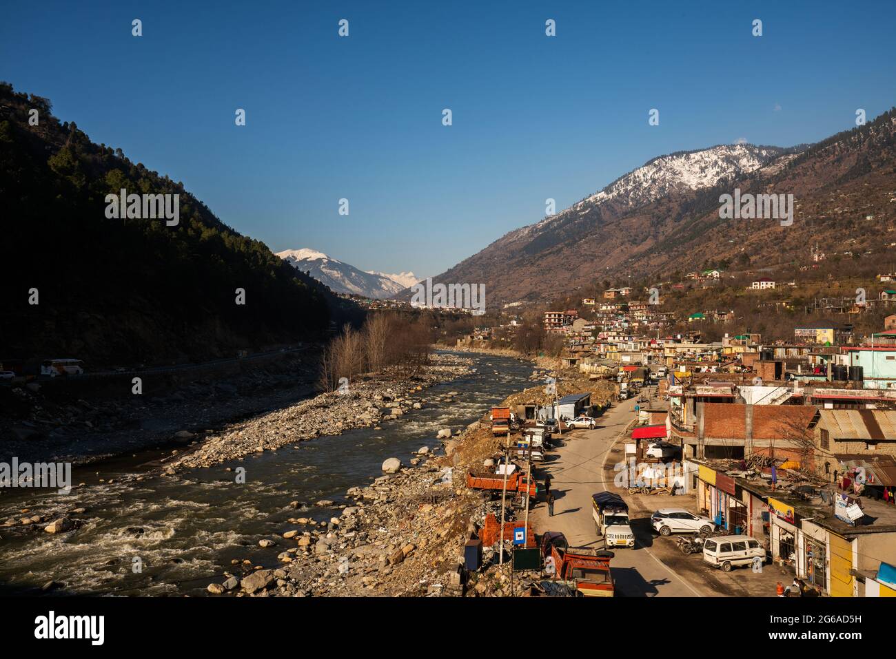 Cool View sulla città di Kullu (proiettili, strada, persone) e il fiume Beas. Himachal Pradesh stato dell'India . Una collina ai piedi dell'Himalaya. - giorno di sole e nevoso Foto Stock
