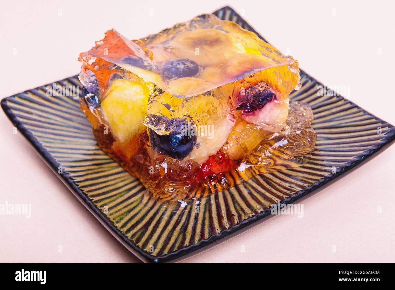 Gelatina di frutta e bacche diverse su un piatto quadrato. Dessert. Primo piano Foto Stock
