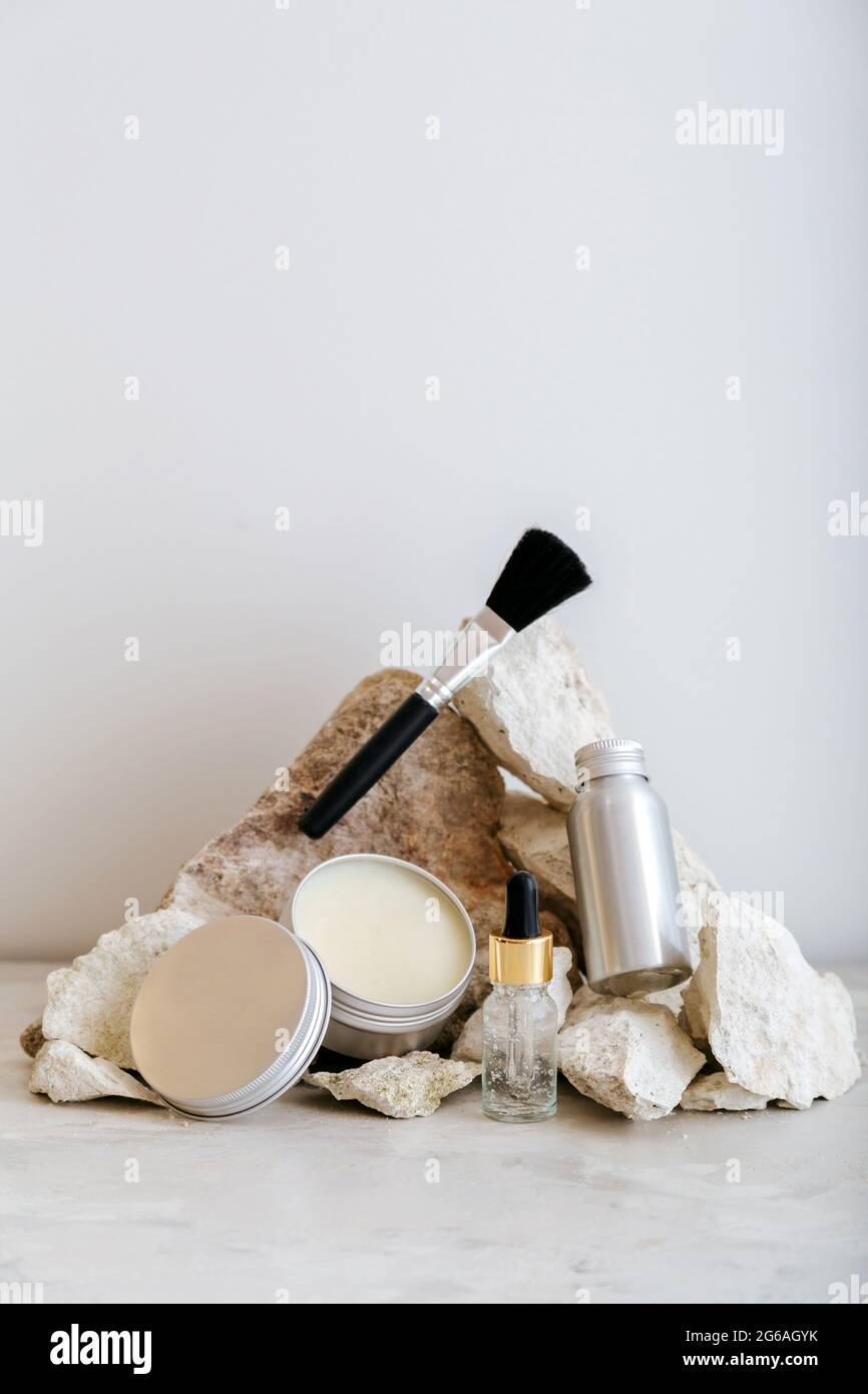 Set di prodotti cosmetici in confezione di alluminio. Prodotti cosmetici zero waste per la cura della pelle con disposizione a piedistallo in pietra color pastello. Estetica minima. Foto Stock