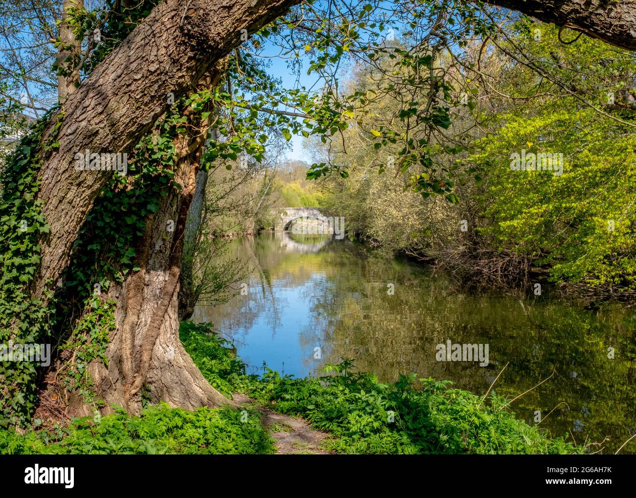 Vecchio ponte di pietra su un piccolo fiume tranquillo, preso in primavera in una giornata di sole a Brunoy (vicino a Parigi), Francia Foto Stock