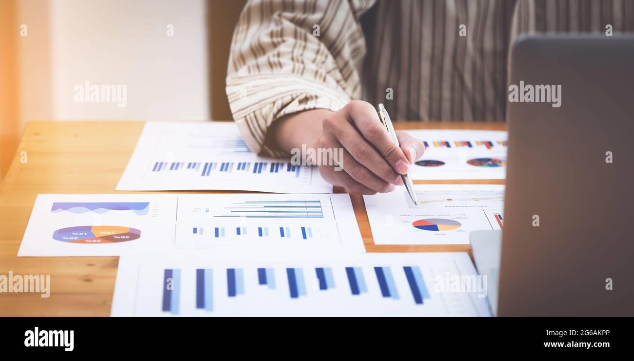 Dopo il punto di metà dell'anno, UN gestore di fondi esamina il grafico finanziario del marketing con la documentazione. Foto Stock
