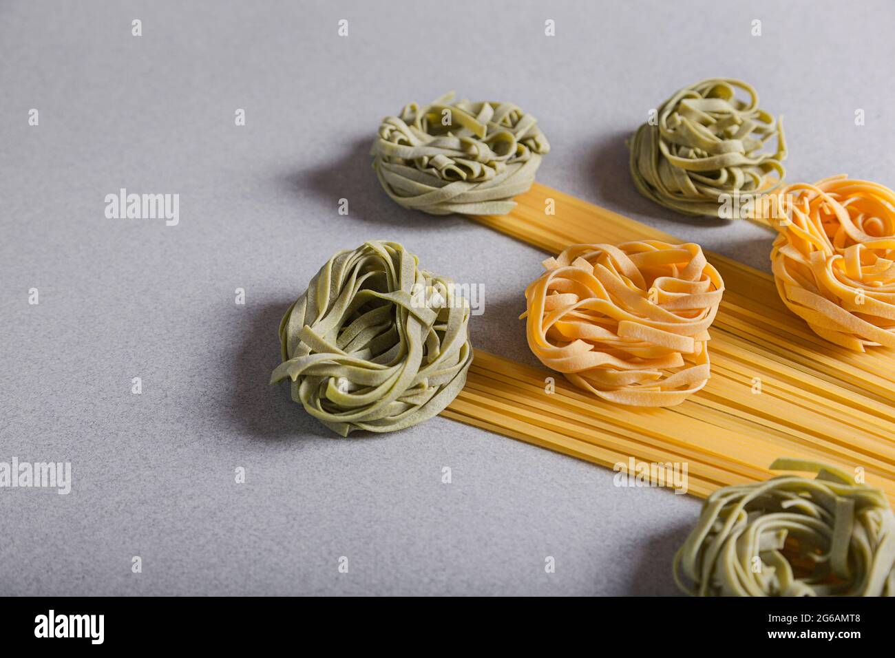 Tagliatelle e Spaghetti verdi e gialli sullo sfondo Foto Stock