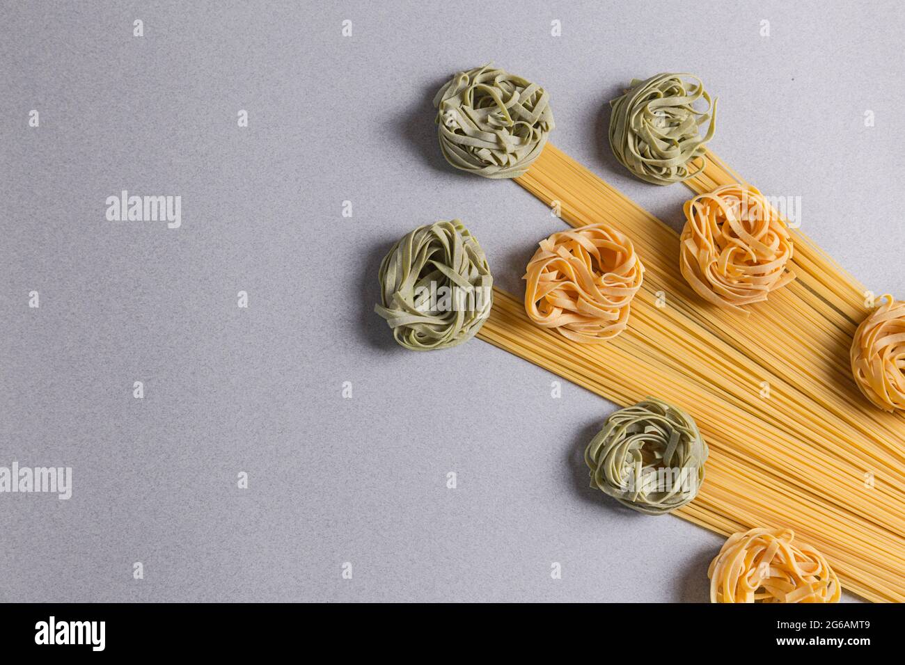 Tagliatelle e Spaghetti verdi e gialli su sfondo chiaro Foto Stock