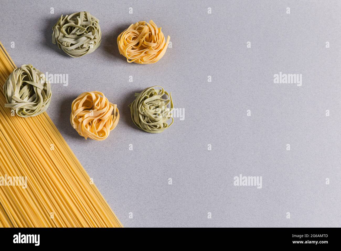Spaghetti e Tagliatelle verdi e gialle su sfondo chiaro Foto Stock