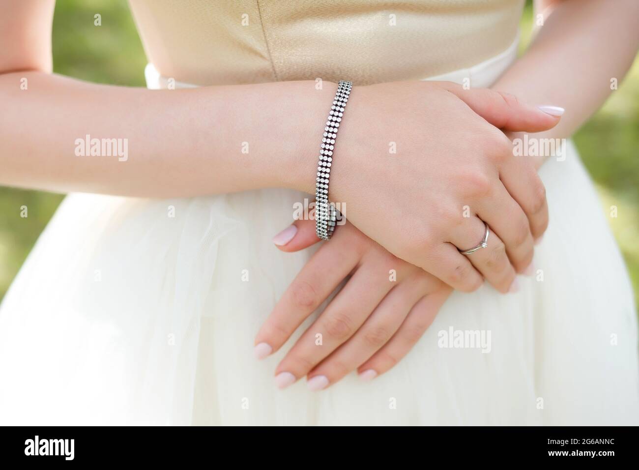Sposa in abito bianco con decorazioni per matrimoni con pietre su dettagli decorativi a mano. Foto Stock