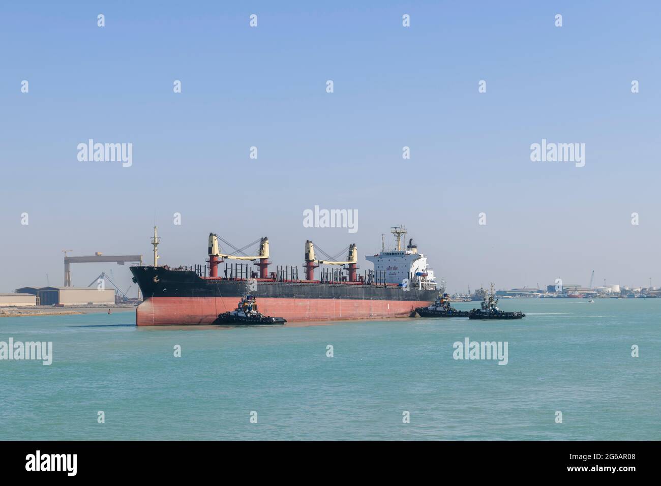 Imbarcazione che si avvicina all'ormeggio con l'assistenza di rimorchiatori. Operazioni di ormeggio. Bulker. Nave di carico asciutta. Foto Stock