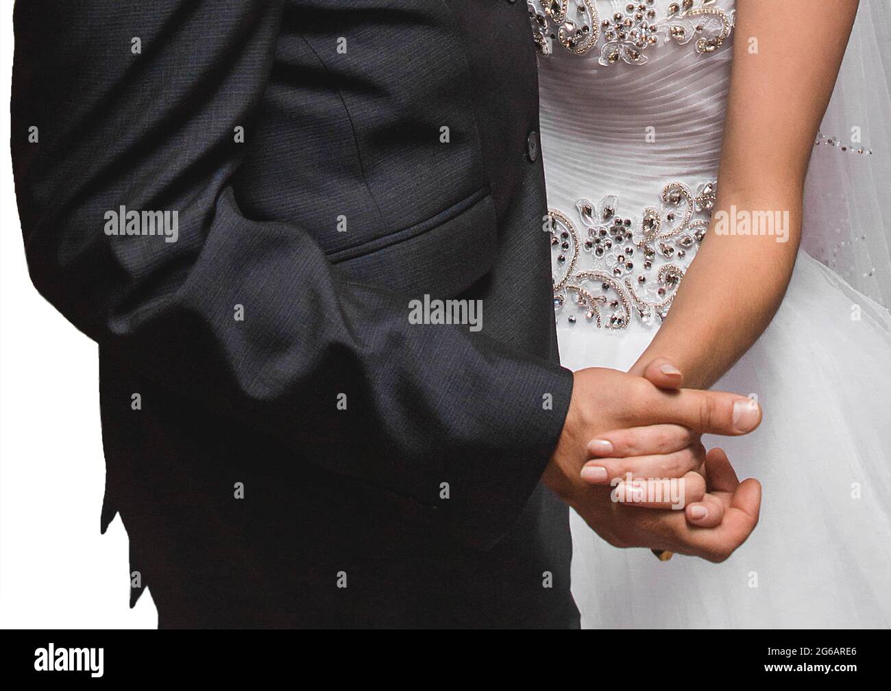 La sposa e lo sposo tengono le mani insieme strettamente da vicino al matrimonio. Foto Stock