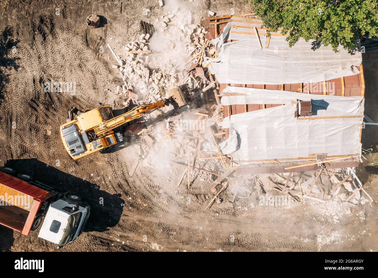 L'escavatore idraulico rompe la casa. Demolizione o distruzione di edifici per New Construction, vista dall'alto aerea. Foto Stock