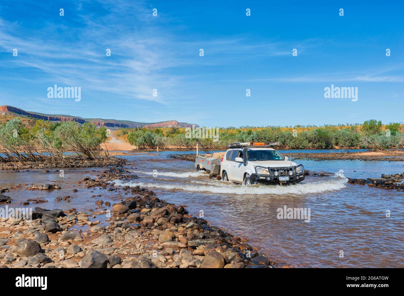 Auto fuoristrada che traina un rimorchio che attraversa l'iconica Pentecoste Crossing, Gibb River Road, Kimberley, Western Australia, WA, Australia Foto Stock