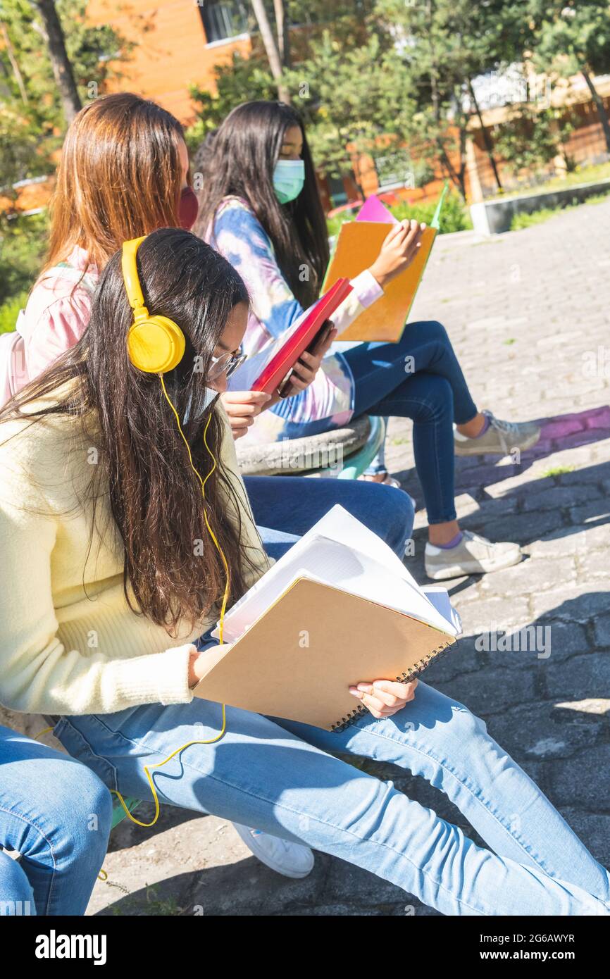 Le adolescenti di Latina studiano all'aperto nel campus della scuola superiore indossando una maschera di prevenzione covid 19. Istruzione e salute Foto Stock