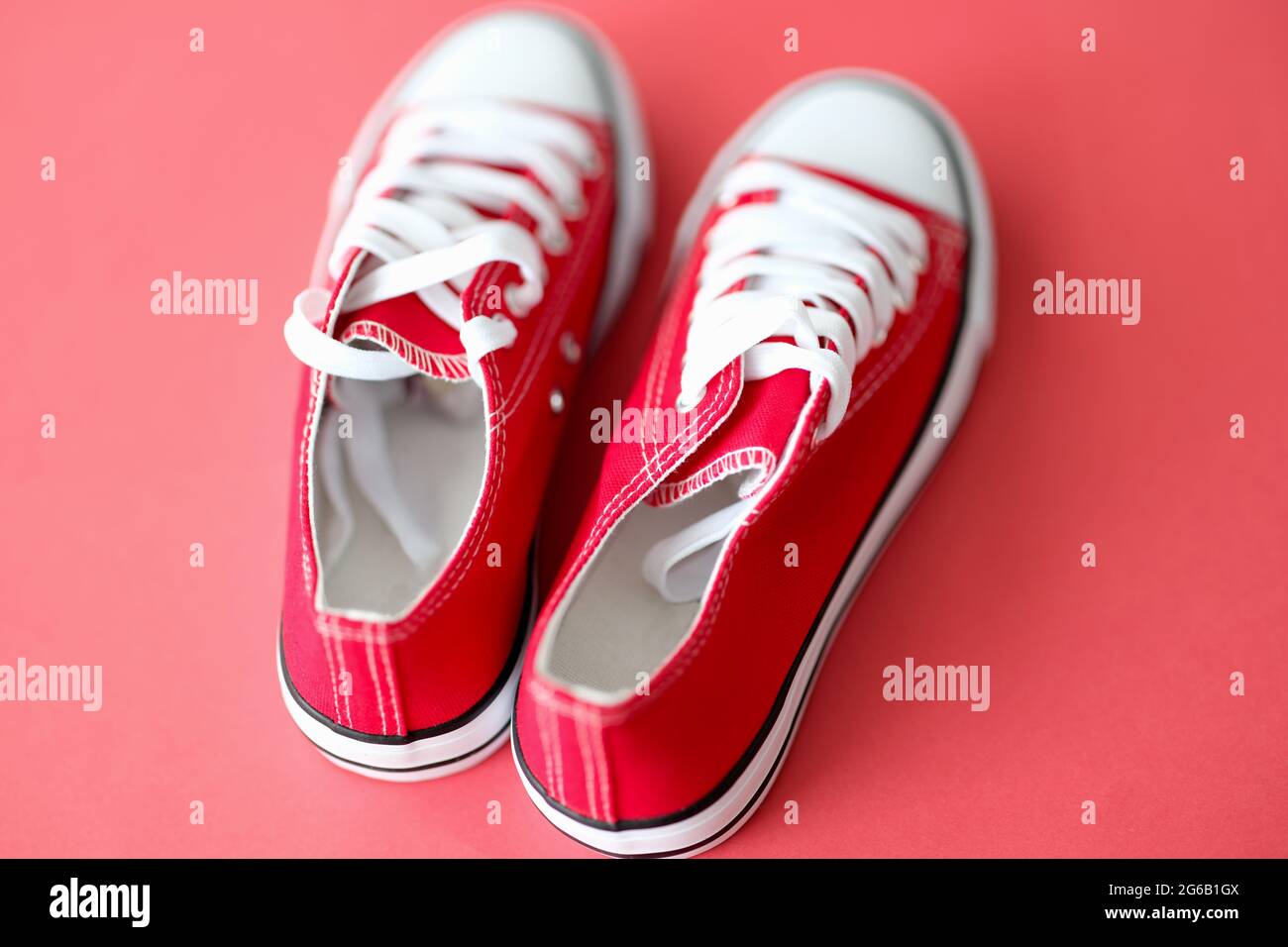 Sneaker rosse con lacci bianchi su un primo piano di sfondo rosso Foto  stock - Alamy