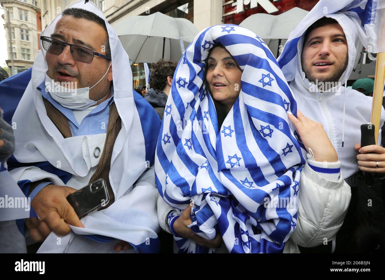 Un manifestante indossa una sciarpa realizzata con materiale ispirato alla  bandiera israeliana durante la protesta.i dimostranti pro-israeliani si  radunano fuori dall'ambasciata israeliana ad High Street Kensington a  sostegno del cessate il fuoco