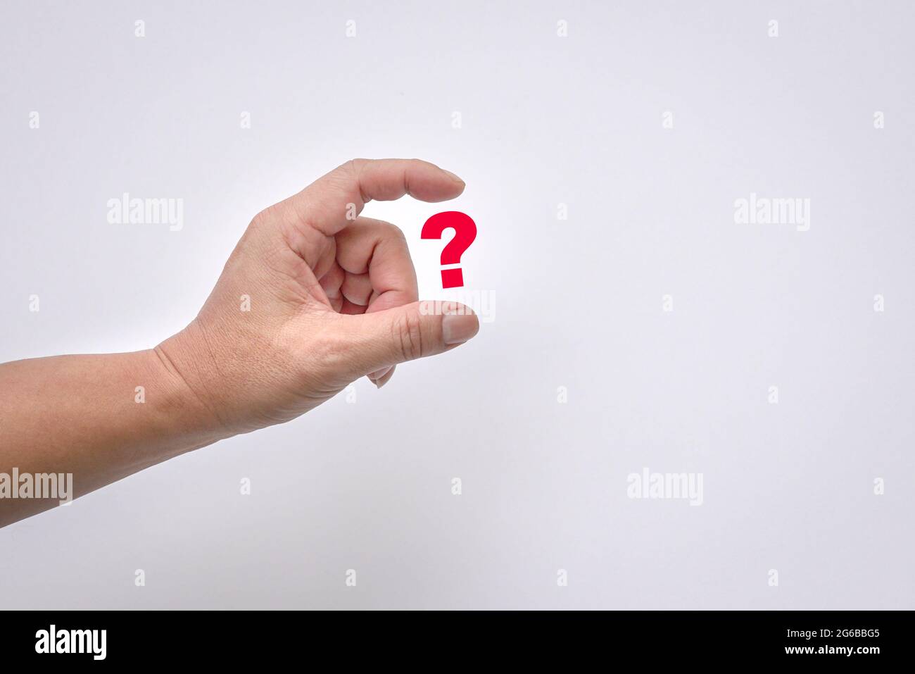 Le dita dell'uomo tengono virtualmente un punto interrogativo rosso su sfondo bianco. Spazio di copia. Foto Stock