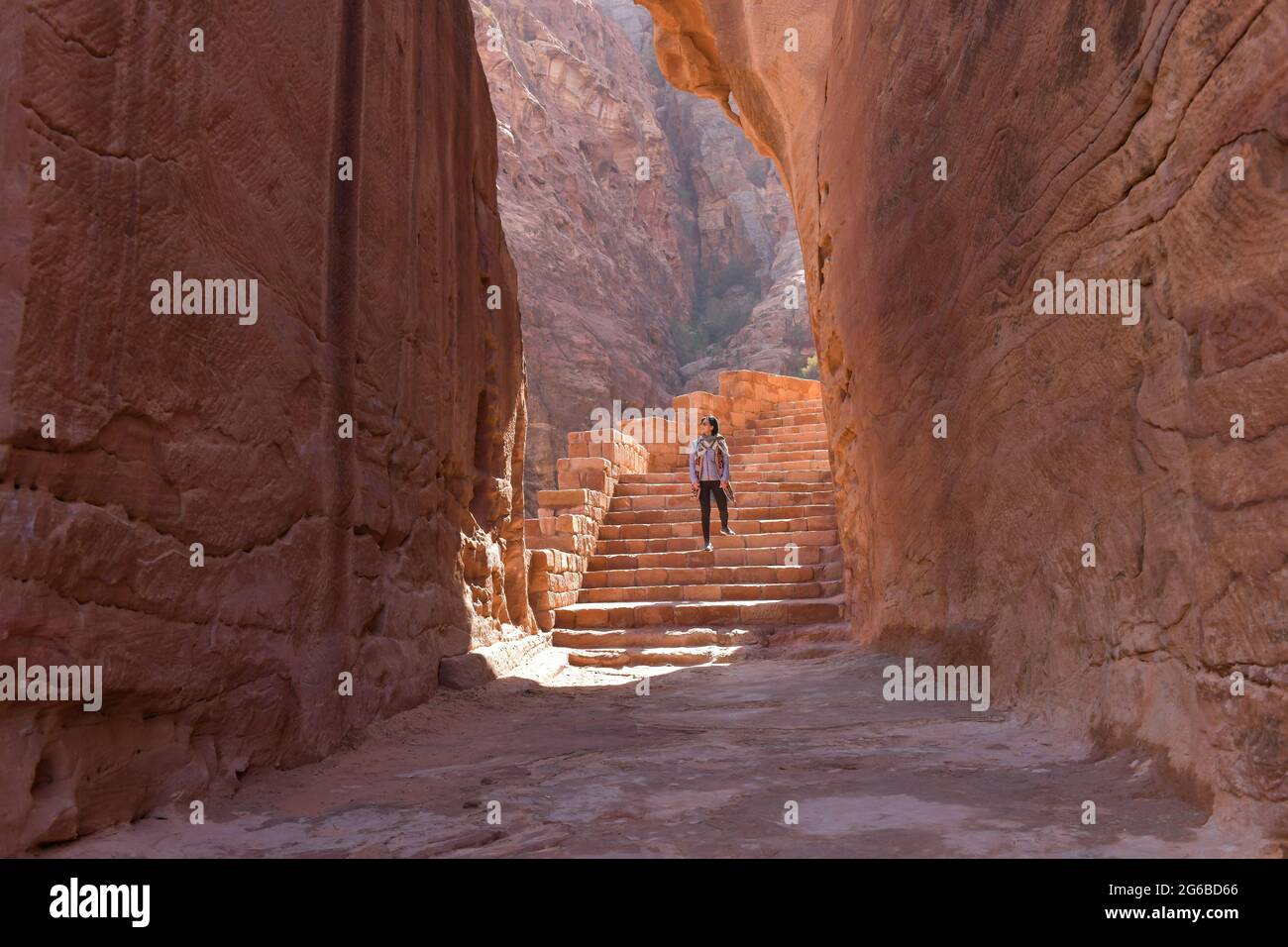 Vista posteriore di una donna che salta le scale nell'antica città di Petra, Giordania Foto Stock