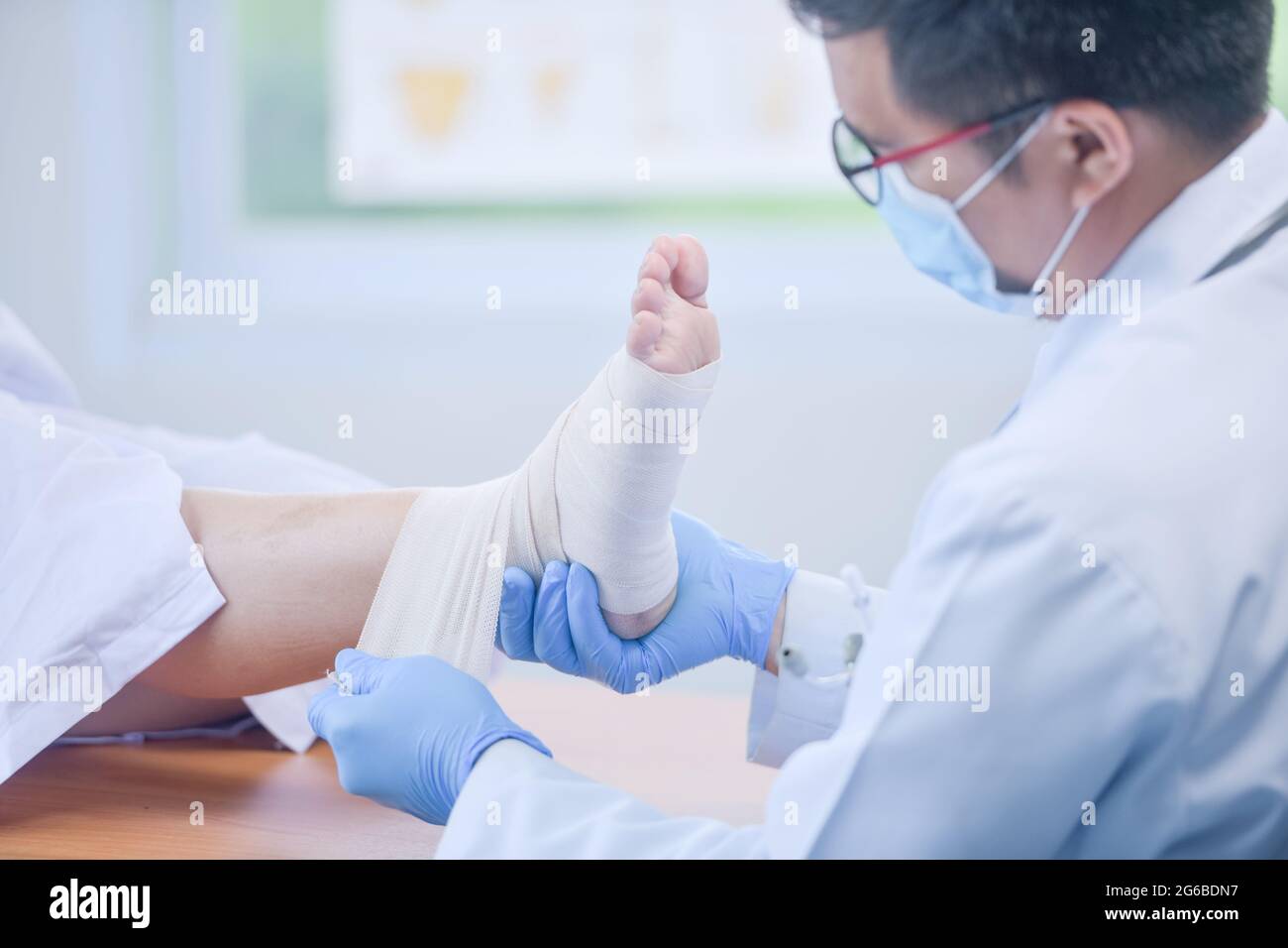 Medico del bendaggio un piede di un paziente Foto Stock
