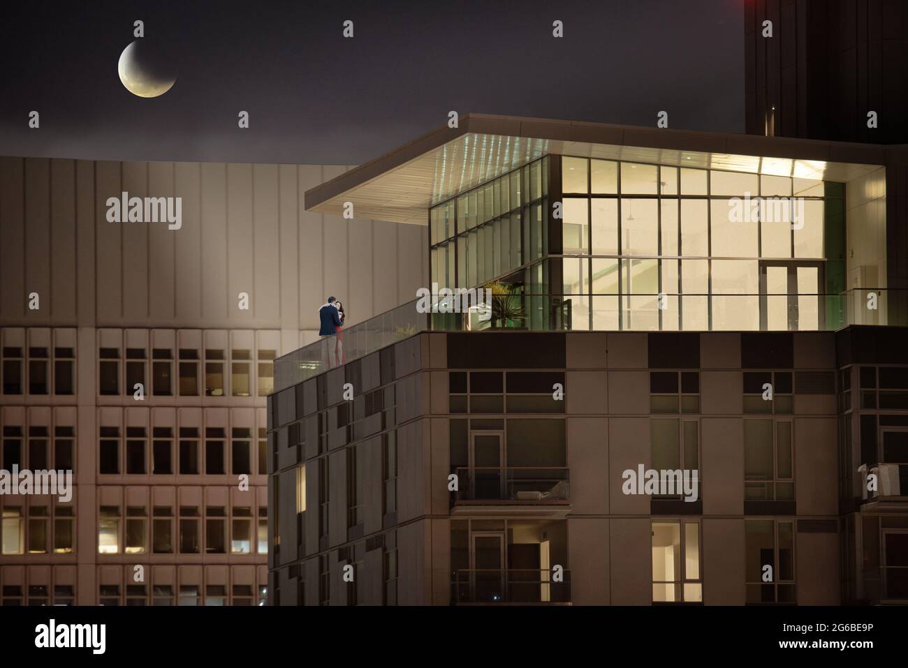 Coppia che si erge su una terrazza sul tetto danzante di notte, Los Angeles, California, USA Foto Stock